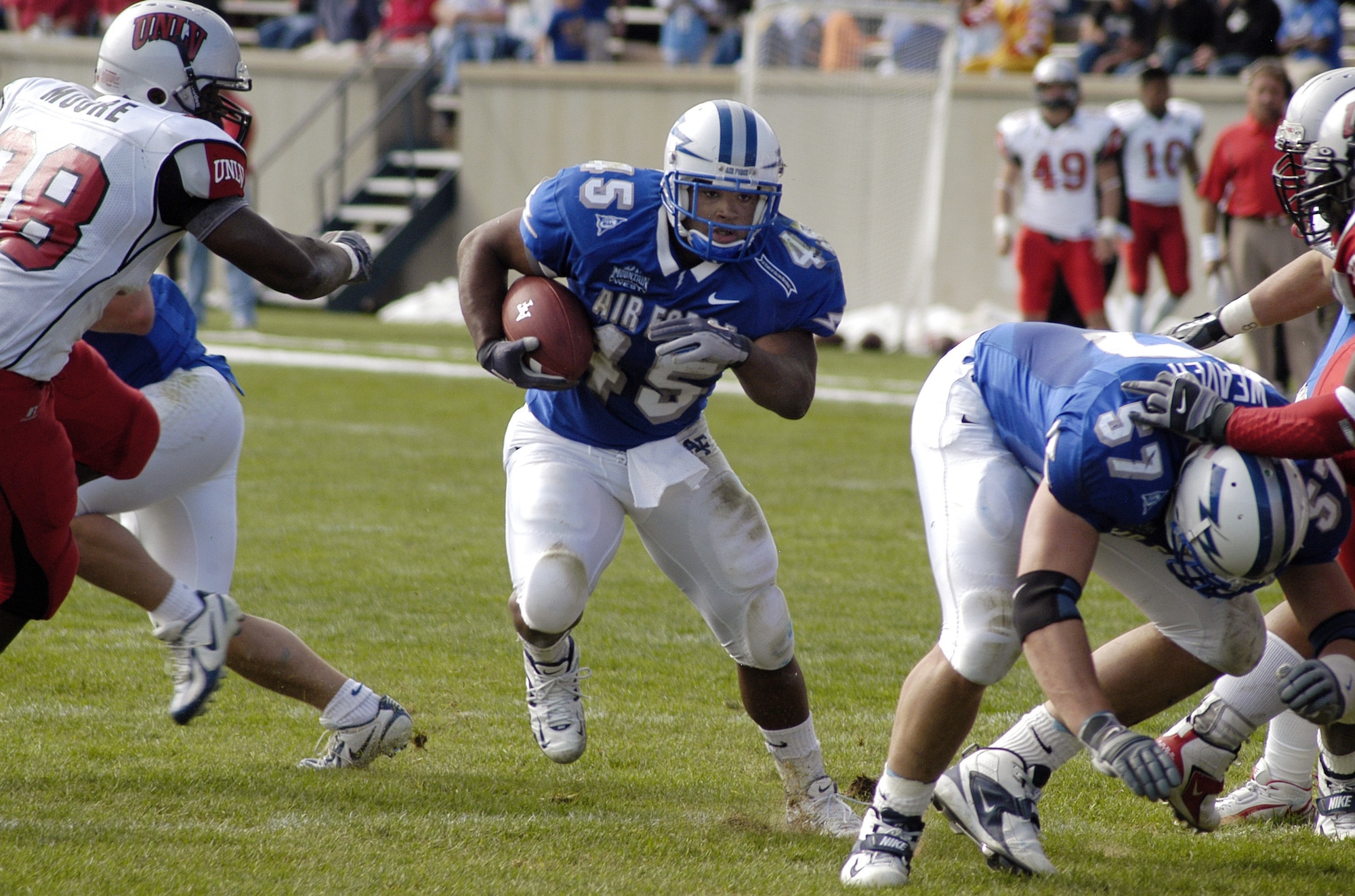 U.S. AIR FORCE ACADEMY, Colo. -- Falcon fullback Ryan Williams, 45, runs to daylight made by offensive tackle Ross Weaver, 57, as UNLV defensive end Leon Moore, 98, closes in. (U.S. Air Force photo by 2nd Lt. John Ross)
