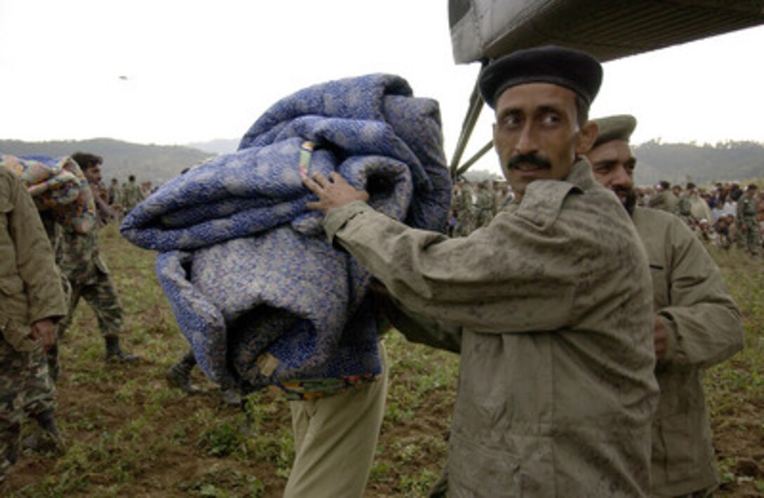 Pakistani soldiers unload blankets and other disaster relief supplies from a U.S. Navy MH-53E Sea Dragon helicopter in Balakot, Pakistan, on Oct. 15, 2005. The Department of Defense is participating in the multinational effort to provide humanitarian assistance and support to Pakistan and parts of India and Afghanistan following a devastating earthquake. 