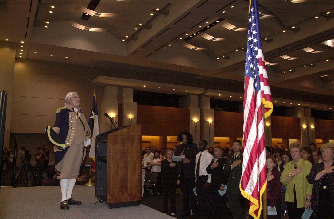 Plano, Texas resident Michael J. Radcliff, a member of the Texas Society of the Sons of the American Revolution, performs a continental salute before retiring the colors for the U.S. naturalization ceremony in the Arlington, Texas Convention Center.  Nearly 500 aliens from 66 foreign countries became citizens in the ceremony.
