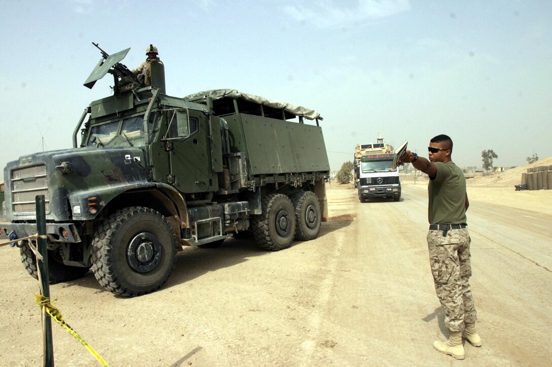 Lance Cpl. Lance M. Simmons, a 20-year-old Starke, Fla. native and traffic management coordinator assigned to Task Force Roadrunner, directs a convoy to an offload area here.