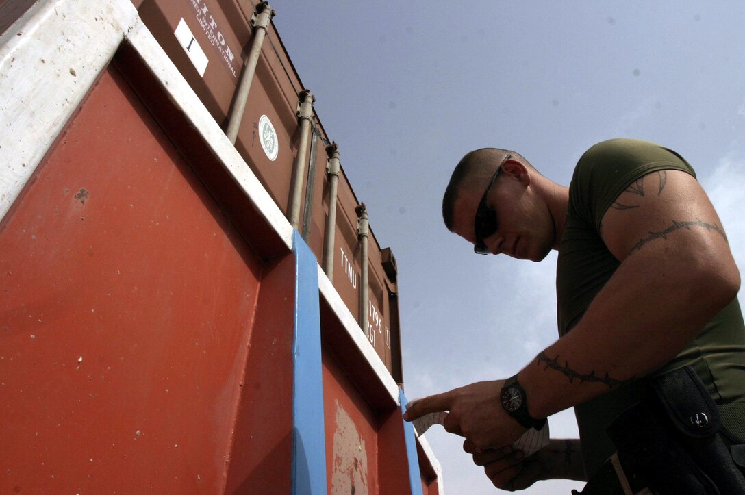 Lance Cpl. Paul M. Moore, a 21-year-old Perryville, Mo. native and motor transportation operator assigned to Task Force Roadrunner checks a packing manifest prior to offloading a convoy here.