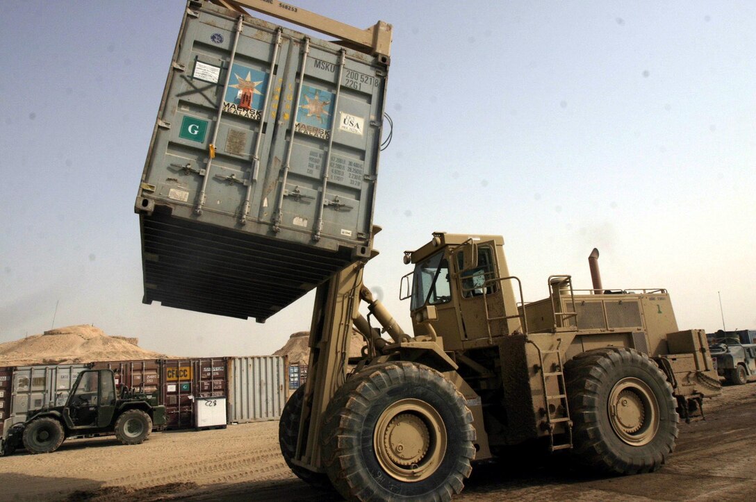 A Rough Terrain Cargo Handler moves an ISO container. Task Force Roadrunner is the only unit here with equipment capable of moving such cargo.