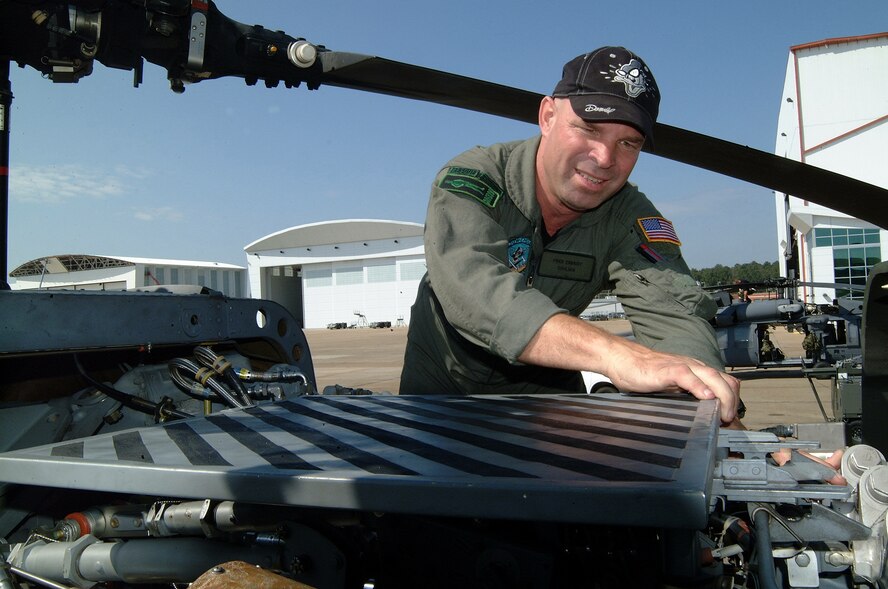 Tech. Sgt. Fred Zobrist, a flight engineer with Air Force Reserve Commands 920th Rescue Wing, Patrick Air Force Base, Fla., moves a panel on an HH-60 Pave Hawk helicopter to service its engine before launching a hurricane search-and-rescue mission from Jackson, Miss. (U.S. Air Force photo by Master Sgt. Bill Huntington)