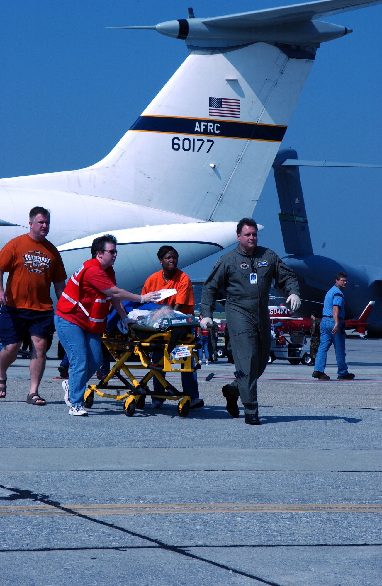050902-F-5515J-002   Volunteers from Dobbins Air Reserve Base, Ga., shuttle a patient who arrived there on a C-141 assigned to Air Force Reserve Commands 445th Airlift Wing, Wright-Patterson Air Force Base, Ohio. About 100 patients were airlifted to Dobbins for transportation to hospitals in Atlanta, one of 17 cities in the country taking 2,500 Hurricane Katrina victims. At Dobbins, the patients went to the 80th Aerial Port Squadron building where Veterans Administration medical people assessed their conditions before they were transported by ambulance to one of 38 Atlanta hospitals. (U.S. Air Force photo by Bo Joyner)
                              