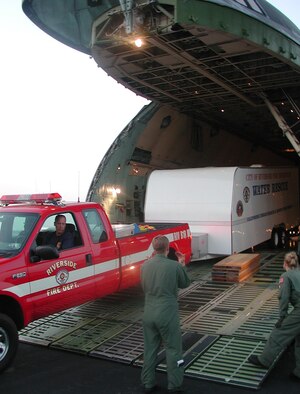 050831-F-7835B-001   LAFAYETTE REGIONAL AIRPORT, La. - Senior Airman Jonathan R. Ash and Tech. Sgt. Ava M. Swedock, 337th Airlift Squadron loadmasters, help a Federal Emergency Management Agency worker drive an emergency vehicle off a C-5 Galaxy Aug. 31. C-5s from Air Force Reserve Commands 439th Airlift Wing, Westover Air Reserve Base, Mass., airlifted FEMA teams from California to Louisiana as part of Hurricane Katrina relief efforts. (U.S. Air Force photo by Tech. Sgt. Andrew Biscoe)