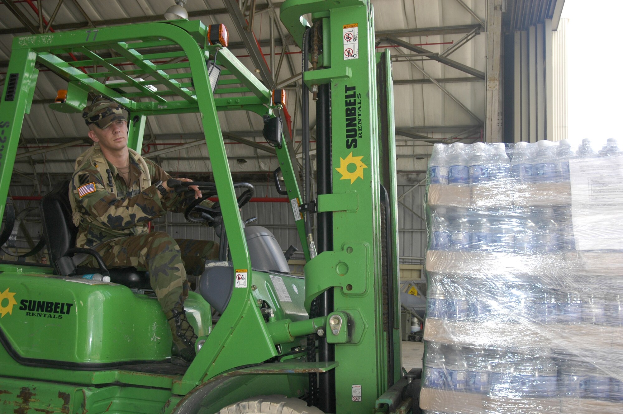 Hurricane Dennis Relief - Army Spc. Virgil Penrod approaches the ramp to load water on an outbound truck at Duke Field, Fla.. His unit is attached to the 927th Corps Support Battalion, Camp Blanding, Starke, Fla. The Florida National Guard unit is assisting with relief efforts for people in areas affected by Hurricane Dennis, which passed over the Florida Panhandle July 10.  (U.S. Air Force photo by Sandie Henry) 