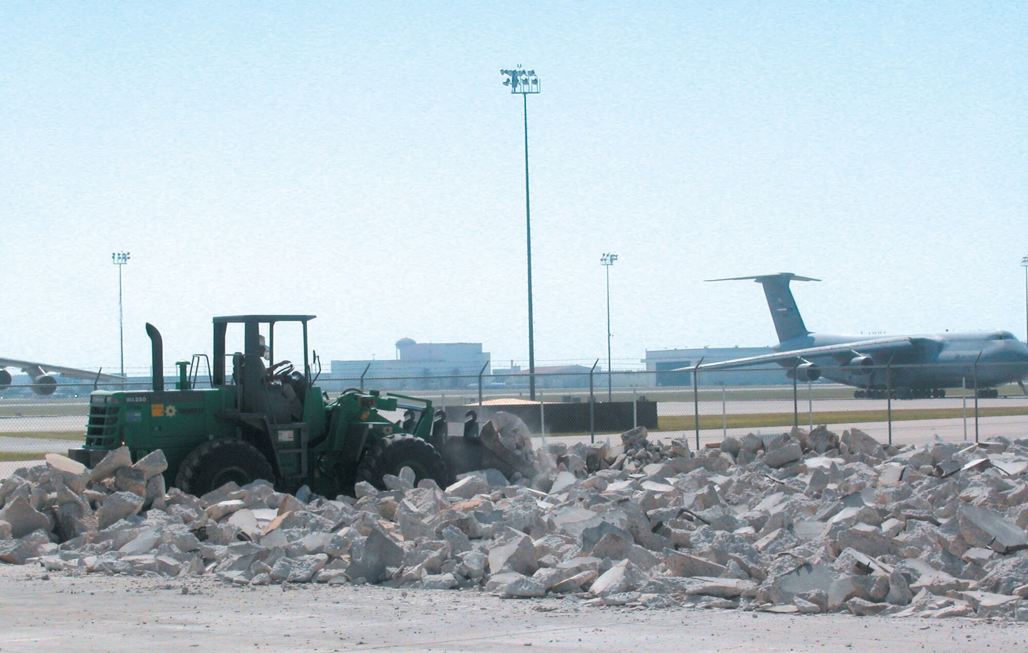 050706-F-7708S-003  A contractor operates a front-end loader to break up cement July 6 as one of the first steps in constructing a ground training school, part of the C-5 Formal Training Unit at Lackland Air Force Base, Texas. Air Force Reserve Command's 433rd Airlift Wing will run the unit. Construction is scheduled to be completed by September 2006. (U.S. Air Force photo by Senior Airman Jonathan Simmons)

