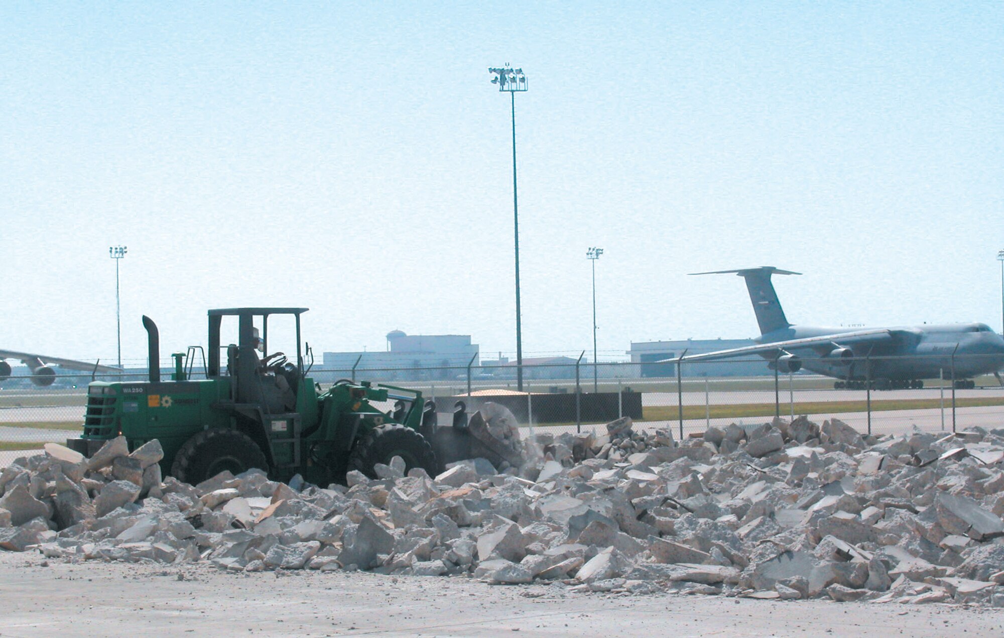 050706-F-7708S-003  A contractor operates a front-end loader to break up cement July 6 as one of the first steps in constructing a ground training school, part of the C-5 Formal Training Unit at Lackland Air Force Base, Texas. Air Force Reserve Command's 433rd Airlift Wing will run the unit. Construction is scheduled to be completed by September 2006. (U.S. Air Force photo by Senior Airman Jonathan Simmons)

