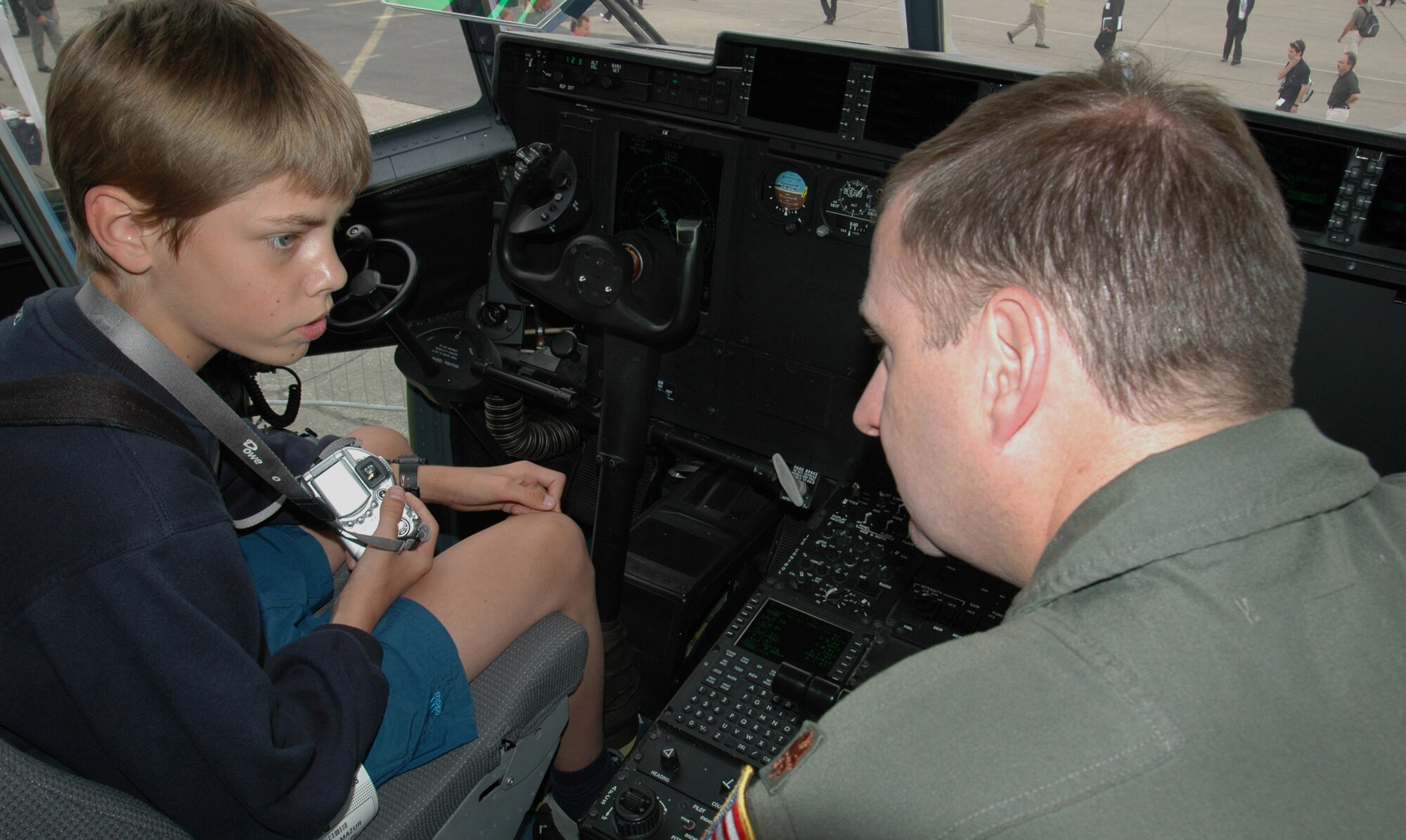 A young aviation enthusiast, Antoni Mazur of Poland, was invited to visit the U.S. Air Force's newsest airlifter the C-130J-30 June 16. Aircraft commander, Maj. Brian Freeman, 815th Airlift Squadron, described some of the new features in the J-model's "glass" cockpit. Computers and Heads Up Displays on the most recent in the Hercules line help improve situational awarness for pilots. 