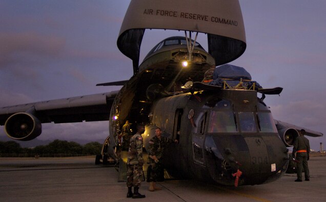 HICKAM AIR FORCE BASE, Hawaii -- Airmen and Soldiers load a CH-47 Chinook heavy lift helicopter onto a C-5 Galaxy here. Company B, 214th Aviation Regiment of the 2nd Battalion, 25th Aviation Regiment at nearby Wheeler Army Air Field, received orders to deploy 60 troops, four helicopters and support equipment to Pakistan to support earthquake relief operations. A total force team here helped load the aircraft Oct. 16. (U.S. Air Force photo by Tech. Sgt. Shane A. Cuomo)