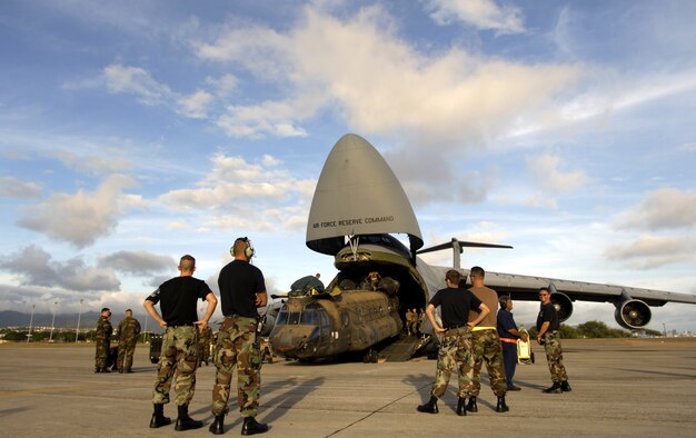 HICKAM AIR FORCE BASE, Hawaii -- Airmen and Soldiers load a CH-47 Chinook heavy lift helicopter onto a C-5 Galaxy here. Company B, 214th Aviation Regiment of the 2nd Battalion, 25th Aviation Regiment at nearby Wheeler Army Air Field, received orders to deploy 60 troops, four helicopters and support equipment to Pakistan to support earthquake relief operations. A total force team here helped load the aircraft Oct. 16. (U.S. Air Force photo by Tech. Sgt. Shane A. Cuomo)