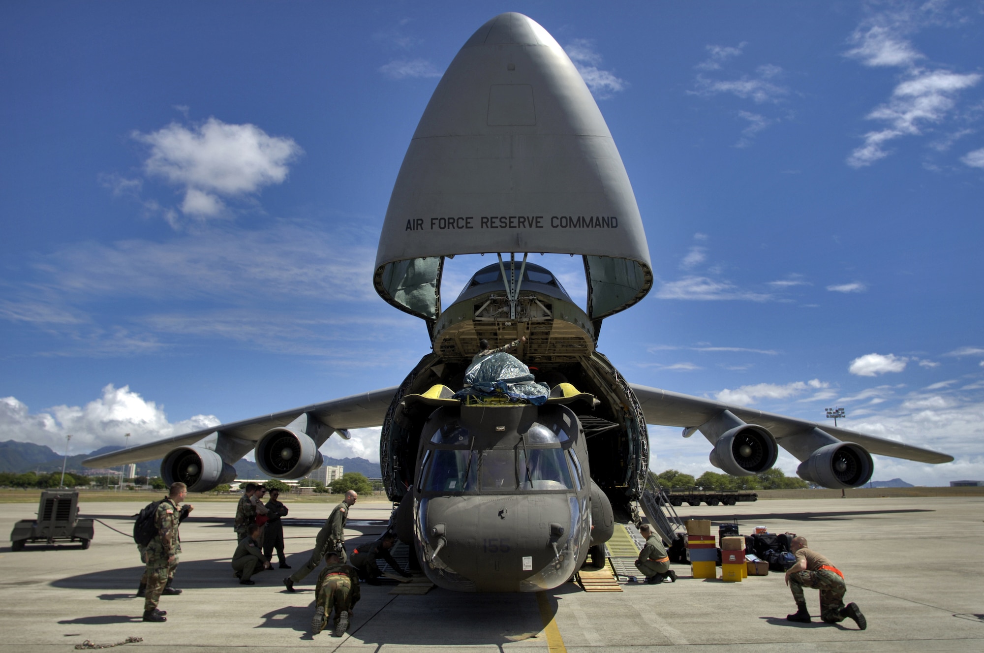 HICKAM AIR FORCE BASE, Hawaii -- Airmen and Soldiers load a CH-47 Chinook heavy lift helicopter onto a C-5 Galaxy here. Company B, 214th Aviation Regiment of the 2nd Battalion, 25th Aviation Regiment at nearby Wheeler Army Air Field, received orders to deploy 60 troops, four helicopters and support equipment to Pakistan to support earthquake relief operations. A total force team here helped load the aircraft Oct. 16. (U.S. Air Force photo by Tech. Sgt. Shane A. Cuomo)