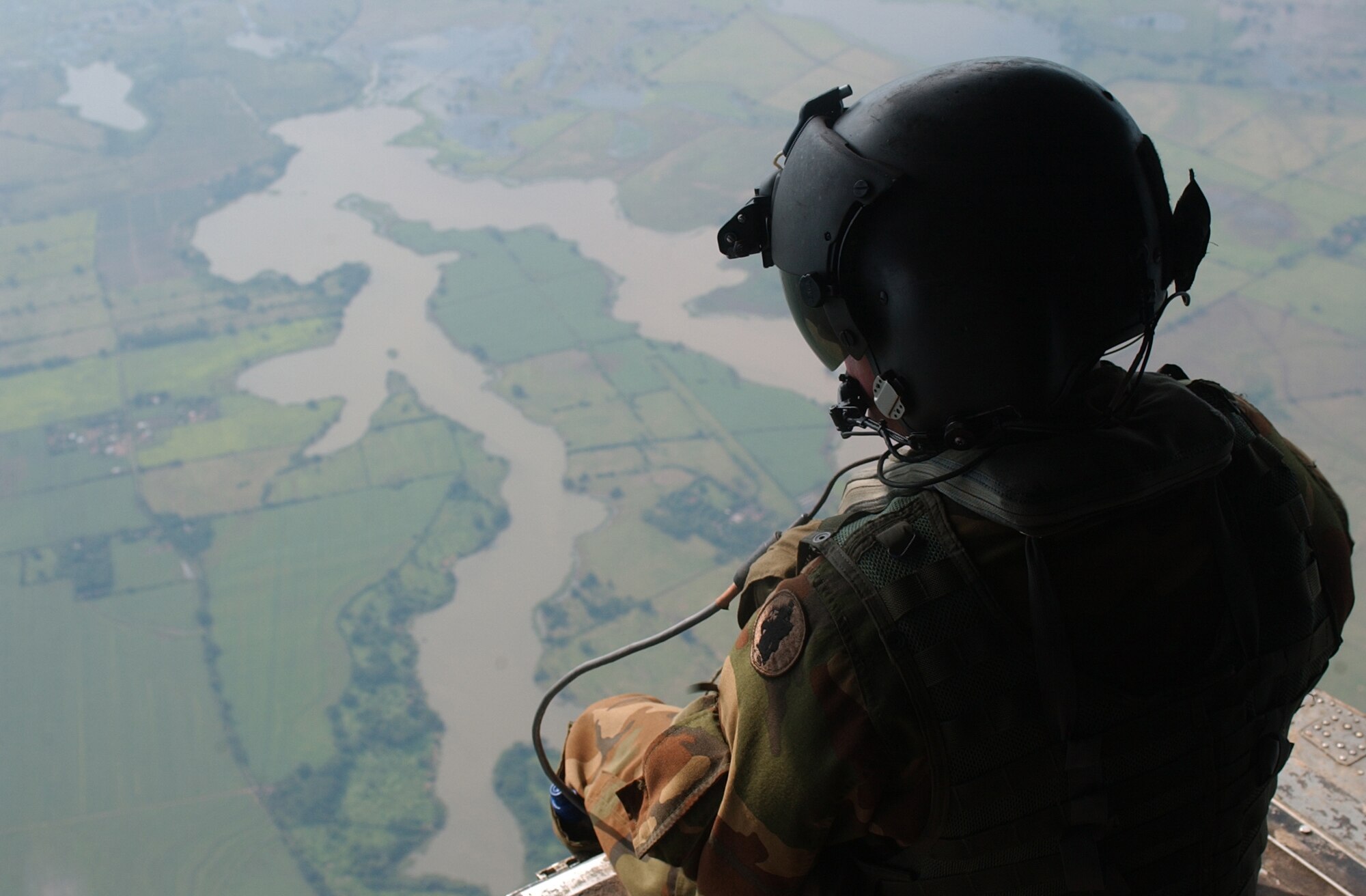 OVER GUATEMALA -- Army Sgt. Damon Houle examines the countryside to assess the damage caused by Hurricane Stan which flooded much of the country. Sergeant Houle and members of Joint Task Force-Bravo arrived here Oct. 7 to help airlift relief supplies to those affected by the hurricane. Sergeant Houle is a crew chief assigned to the 1st Battalion, 228th Aviation Regiment. (U.S. Air Force photo by Tech. Sgt. Mike Edwards)                              