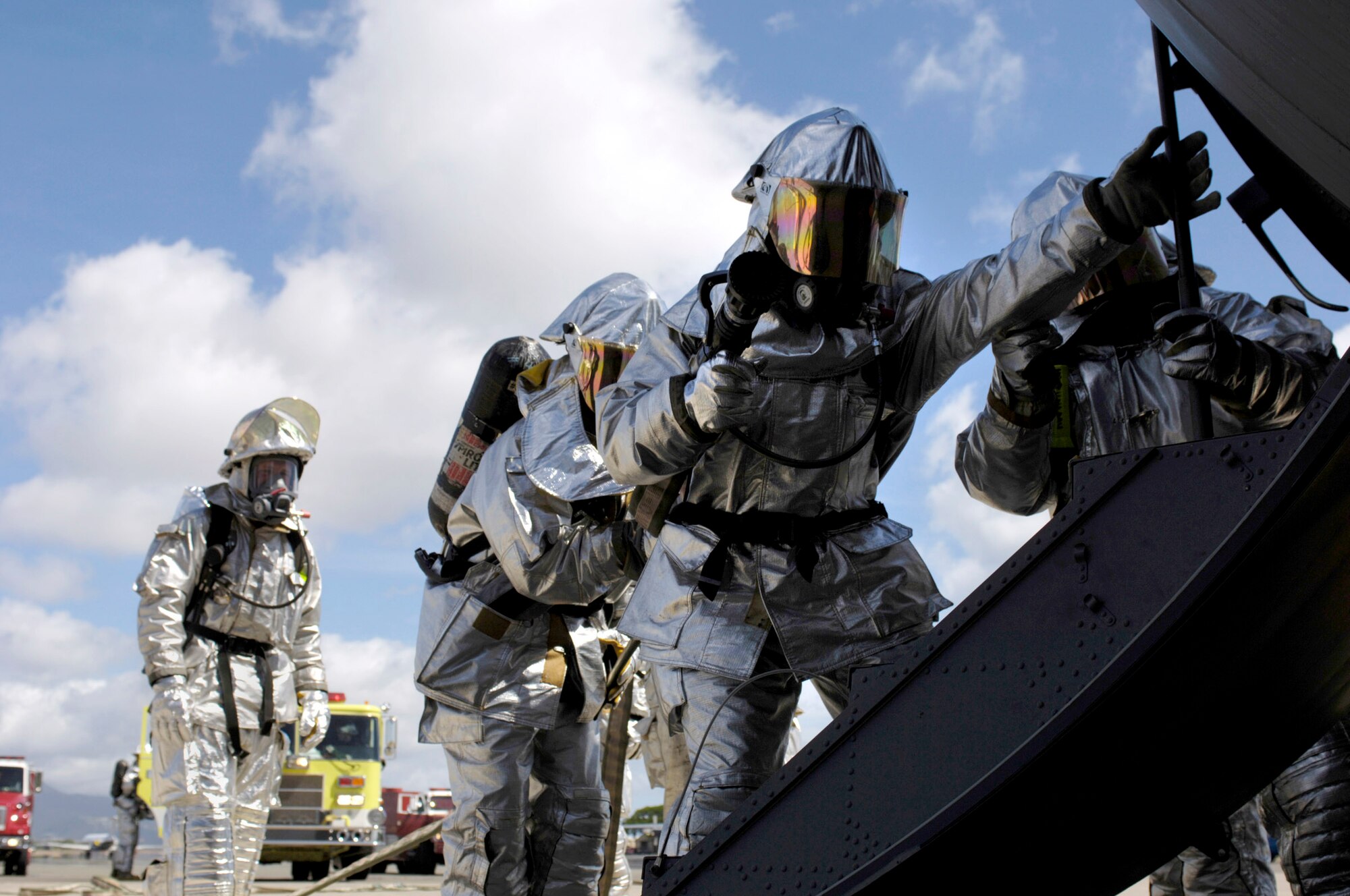 HICKAM AIR FORCE BASE, Hawaii -- Firefighters from the 15th Airlift Wing fire department enter a C-130 Hercules with a simulated flash fire as part of initial response readiness exercise here. The exercise, held Oct. 17, marks the first time the base used an actual C-130 Hercules and aircrew to increase the training's realism. The wing's search and rescue team also took part, entering the aircraft -- from the Hawaii Air National Guard's 154th Wing -- to retrieve and process "bodies." The exercise also tested the interaction between the two wings. (U.S. Air Force photo by Tech. Sgt. Shane A. Cuomo)