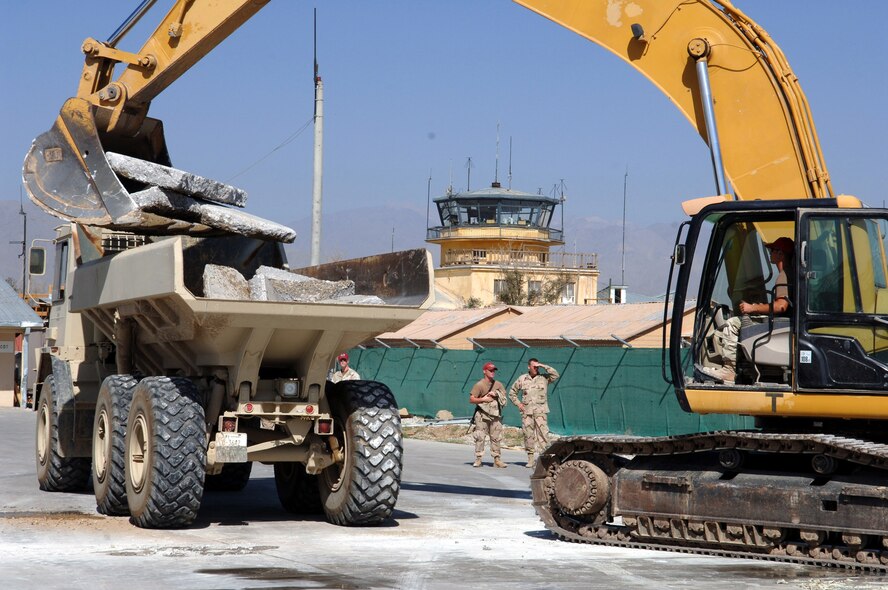BAGRAM AIR FIELD, Afghanistan -- Staff Sgt. David Famigiletti, a pavement and heavy equipment operator, tops off the first load of landfill-bound demolished concrete at the groundbreaking of the new passenger terminal here Oct. 17. The 1st Expeditionary Red Horse Group is here to build the 7,750-square-foot terminal, which they expect to open in early 2006. The sergeant deployed here from Nellis Air Force Base, Nev. (U.S. Air Force photo by Staff Sgt. Marcus McDonald)