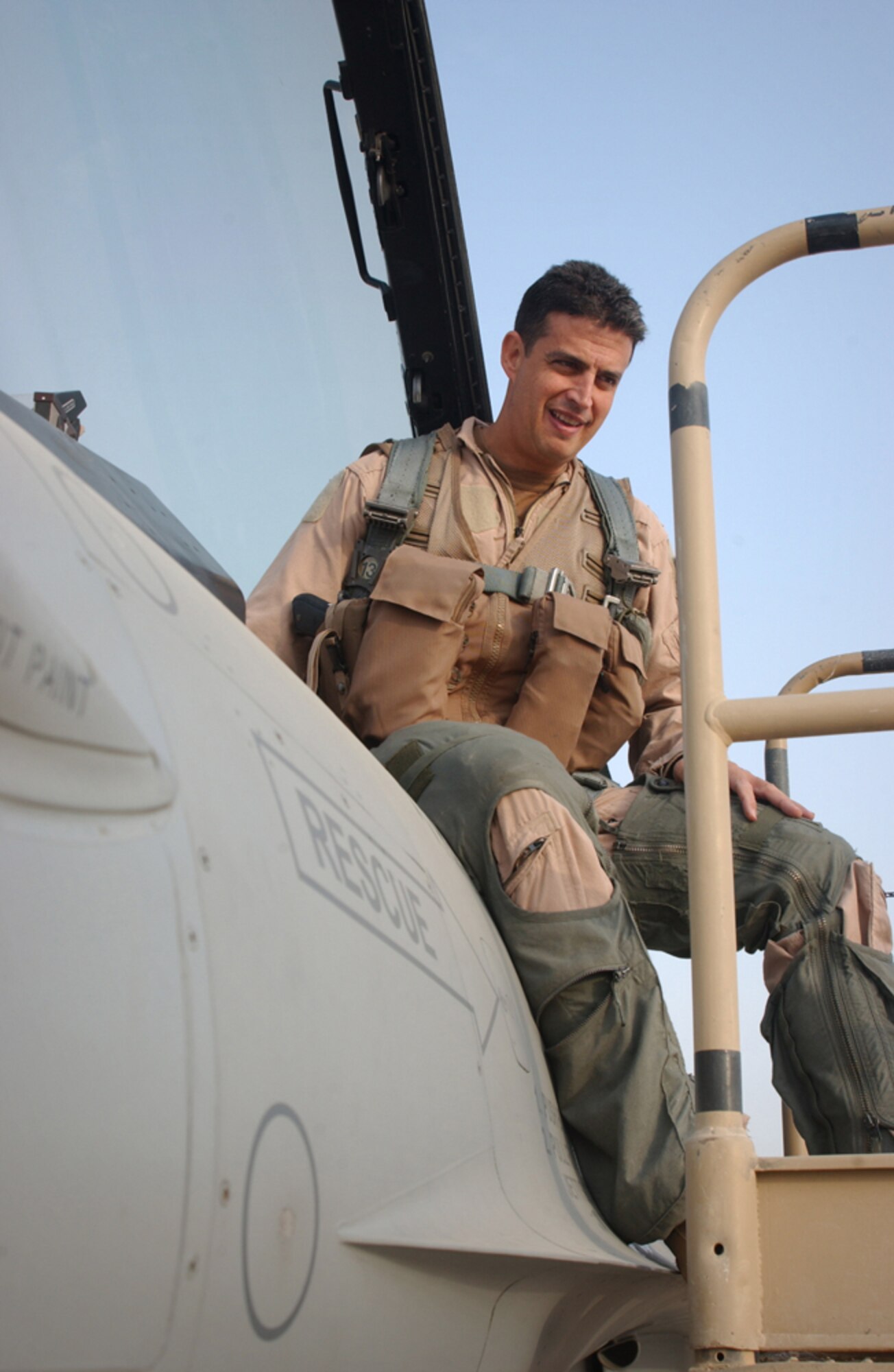 ALI BASE, Iraq -- After spending here because of a weather diversion, Lt. Col. Jose Monteagudo gets into the cockpit of his F-16 Fighting Falcon Oct. 18. The colonel flies with the 332nd Expeditionary Fighter Squadron at Balad Air Base, Iraq. He is deployed from the 482nd Fighter Wing at Homestead Air Reserve Base, Fla. The fighters provide air support to Operation Iraqi Freedom coalition ground forces. (U.S. Air Force photo by Tech. Sgt. Paul Dean)