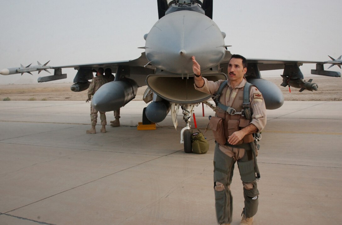 ALI BASE, Iraq -- After spending the night here because of a weather diversion, Maj. Darren Censullo, an F-16 Fighting Falcon pilot, does a preflight walk around his aircraft before takeoff Oct. 18. A reservist, the major flies with the 332nd Expeditionary Fighter Squadron at Balad Air Base, Iraq. He is deployed from the 482nd Fighter Wing at Homestead Air Reserve Base, Fla. The fighters provide air support to Operation Iraqi Freedom coalition ground forces. (U.S. Air Force photo by Tech. Sgt. Paul Dean)
