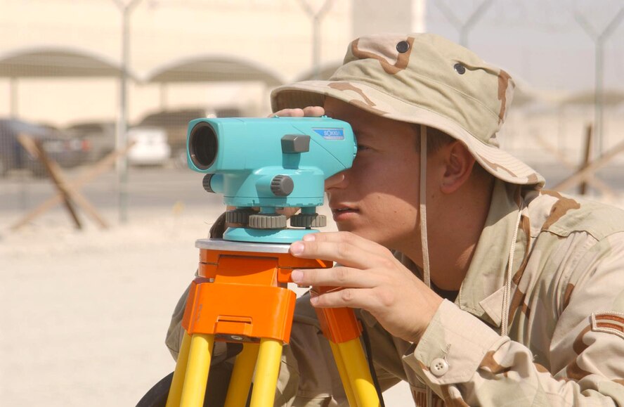 SOUTHWEST ASIA -- Airman 1st Class Shawn Hamilton uses an auto level to "shoot" the grade of a future building development site at this desert air base. The Airman, with the 380th Expeditionary Civil Engineering Squadron, deployed here from Dover Air Force Base, Del. (U.S. Air Force photo by Tech. Sgt. Mike Hammond)