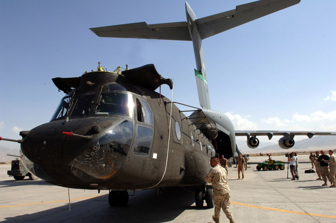 BAGRAM AIR FIELD, Afghanistan -- Airmen offload a CH-47 Chinook heavy lift helicopter from the back of a C-17 Globemaster III here. The helicopter arrived in parts from Fort Hood, Texas. After reassembly, it will fly to Pakistan to help with earthquake relief operations. This was the first of 30 CH-47s to transit through Bagram. The base has been a hub of relief efforts. (U.S. Air Force photo by Capt. James H. Cunningham) 