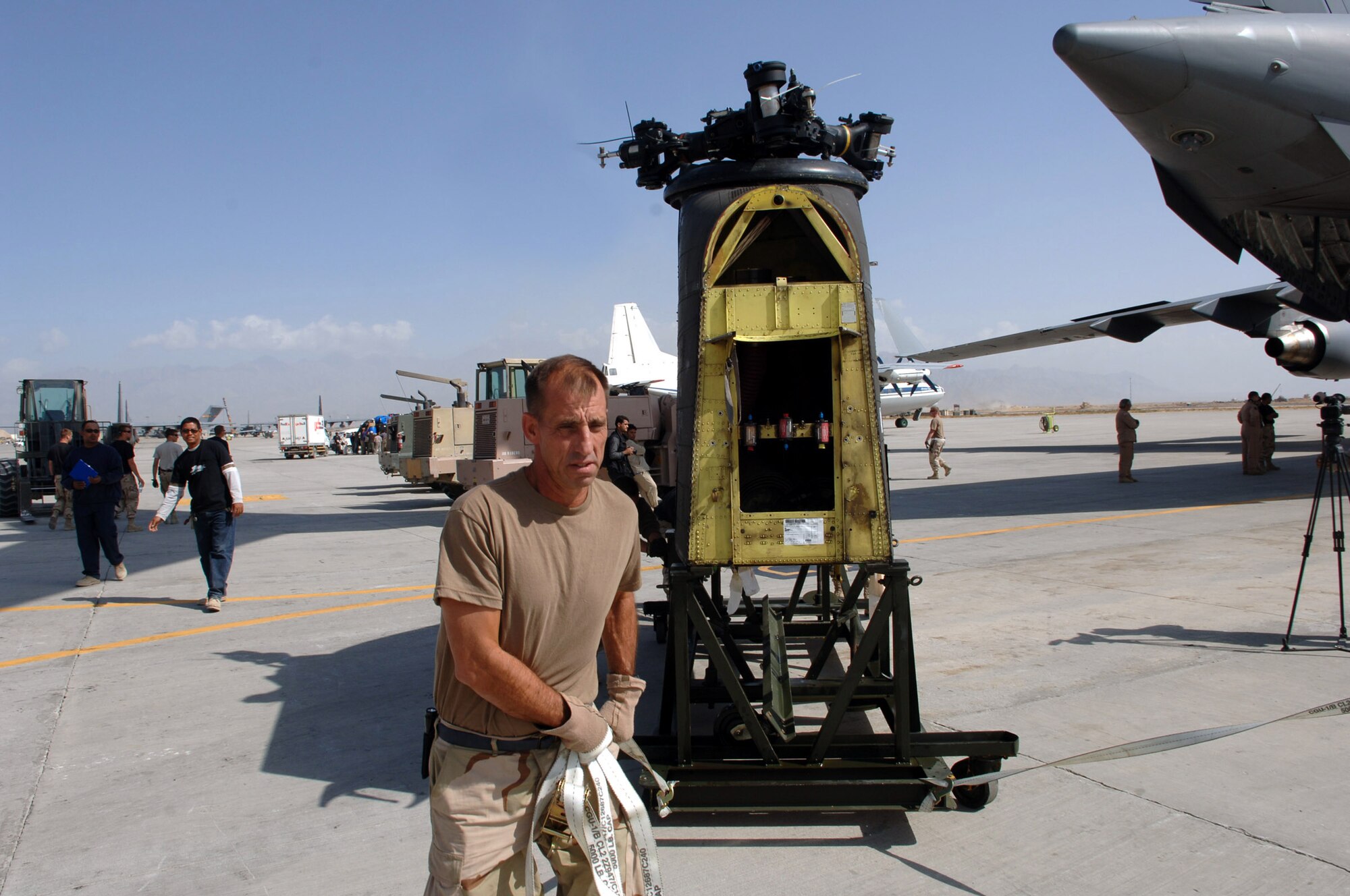 BAGRAM AIR FIELD, Afghanistan -- Master Sgt. Harold Miller rolls the back rotor of a CH-47 Chinook heavy lift helicopter off the back of a C-17 Globemaster III here. The helicopter arrived in parts from Fort Hood, Texas. After reassembly, it will fly to Pakistan to help with earthquake relief operations. This was the first of 30 CH-47s to transit through Bagram. The base has been a hub of relief efforts. Master Sgt. Miller, the ramp services team chief with the 455th Expeditionary Logistics Readiness Squadron is deployed here from Charleston, West Virginia.  (U.S. Air Force photo by Capt. James H. Cunningham)