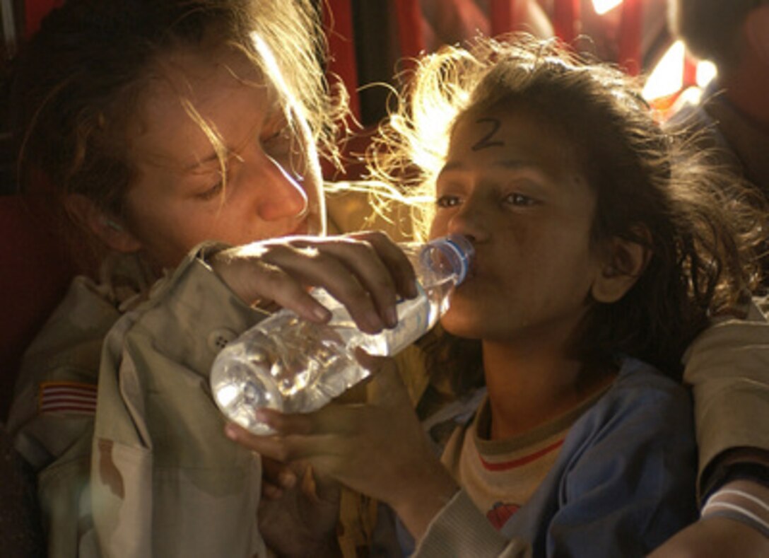 U.S. Army Sgt. Kornelia Rachwal gives a young Pakistani girl a drink of water as they are airlifted from Muzaffarabad to Islamabad, Pakistan, aboard a U.S. Army CH-47 Chinook helicopter on Oct. 19, 2005. The Department of Defense is participating in the multinational effort to provide humanitarian assistance and support to Pakistan and parts of India and Afghanistan following a devastating earthquake. 