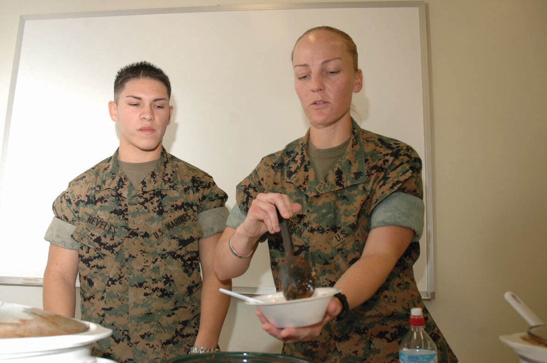 Corporal Jessica Peterson (right), Marine Aviation Logistics Squadron 13 security chief and native of Los Alamitos, Calif., and Lance Cpl. Bernie Reveles, MALS-13 administrative clerk and native of Morino Valley, Calif., dish up a bowl of chili at the MALS-13 Key Volunteer Network chili cook-off Oct. 19 in the MALS-13 conference room. Spectators were able to join in the festivities by buying a bowl of chili, chips and drink for $2, with the money going to support KVN events for the Marines of MALS-13.