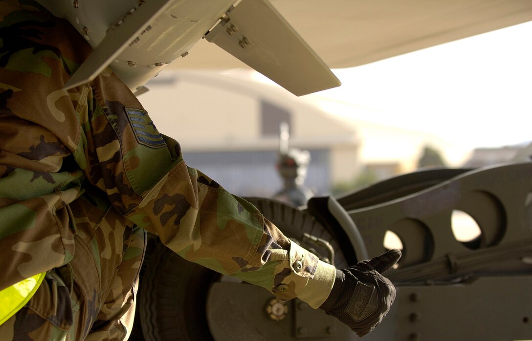 HILL AIR FORCE BASE, Utah -- Tech. Sgt. Shawn Mullins, a weapons load crew chief, signals his weapons load driver to raise a joint direct attack munition into the bomb bay of an F/A-22 Raptor here. The bomb load, on Oct. 18, was part of exercise Combat Hammer. The Raptors are from the 27th Fighter Squadron at Langley, Air Force Base, Va. The unit deployed here Oct. 15 with a twofold goal: complete a deployment and to generate a combat-effective sortie rate away while deployed. (U.S. Air Force photo by Staff Sgt. Samuel Rogers) 