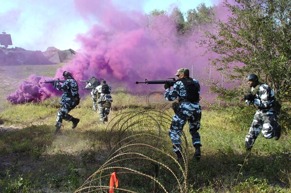 EGLIN AIR FORCE BASE, Fla. -- Amid purple smoke, "opposing forces" attack the defensive fighting position at a 728th Air Control Squadron deployed radar site. The training was part of an operational readiness inspection here. (U.S. Air Force photo by 1st Lt. David Tomiyama)