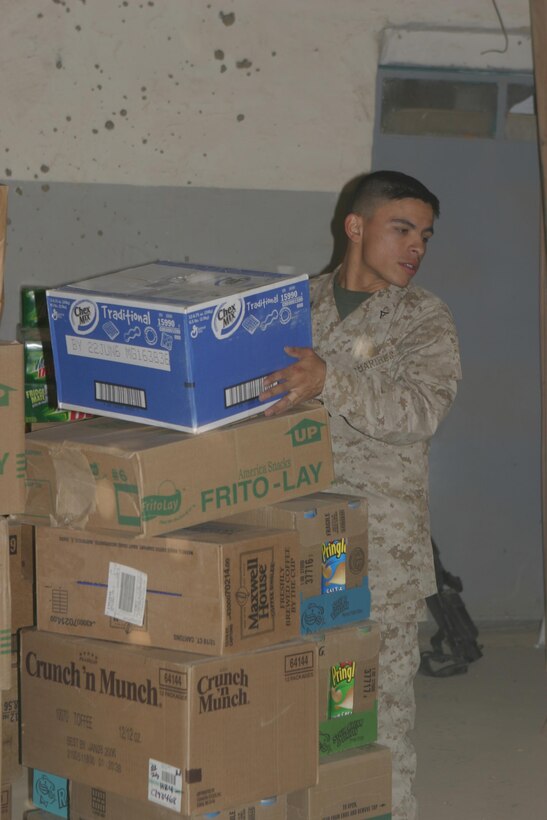 Lance Cpl. Juan J. Rivera prepares his stacks boxes of food here Oct. 23. The small group of exchange Marinestravels from Camp Taqaddum, Iraq, to various forward operating bases to bring a small piece of comfort to service members who don?t have the luxury of an immediate post exchange at their location. Rivera is an exchange Marine with 2nd Force Service Support Group (Forward).