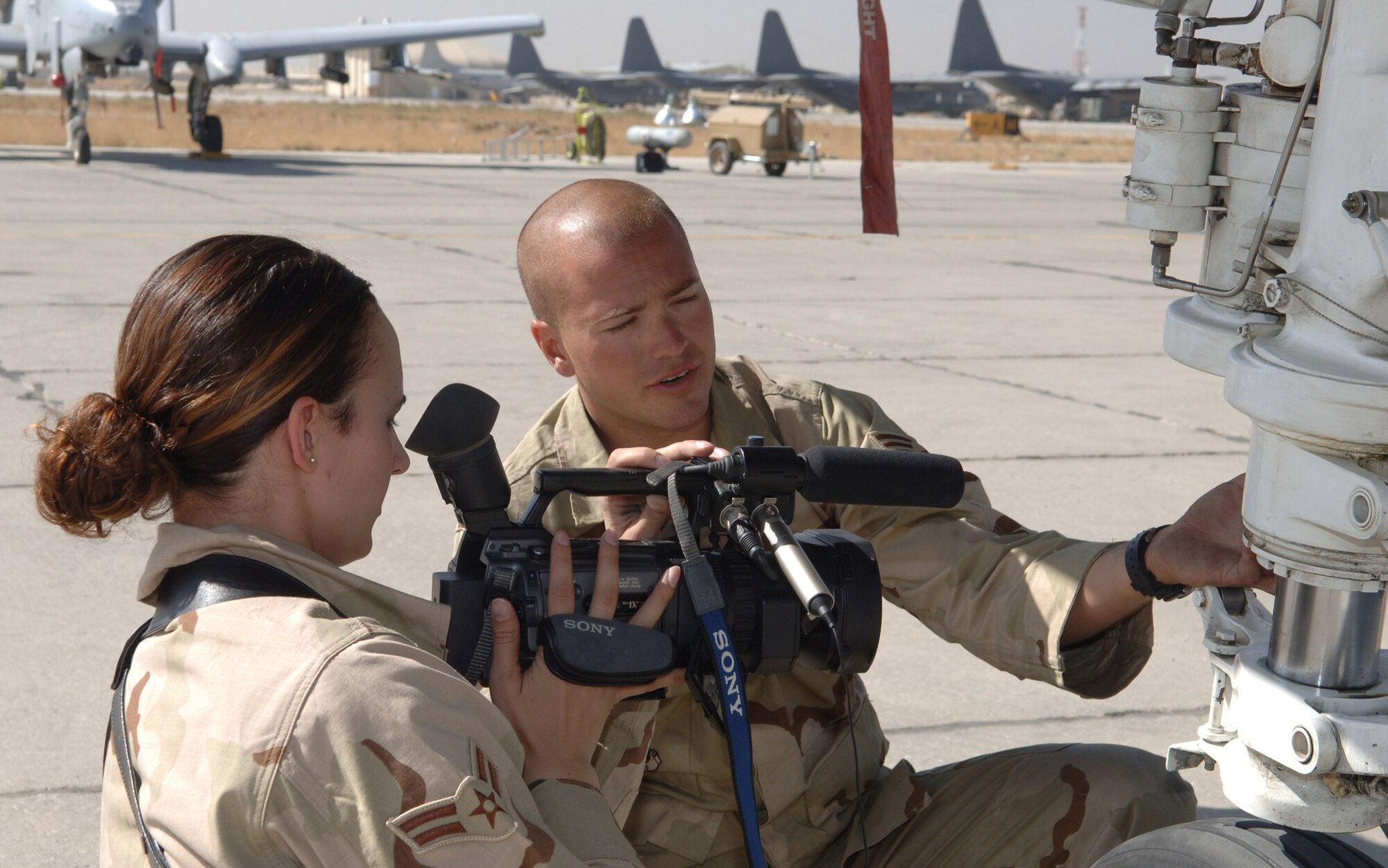 BAGRAM AIR FIELD, Afghanistan -- Airman 1st Class Sasha Schmidt interviews A-10 Thunderbolt II crew chief Senior Airman Earlray Haag for a news story on the aircraft's role in Operation Enduring Freedom.  Airman Schmidt, deployed from Vicenza, Italy, is part of the team of broadcasters from the Air Force Broadcasting Service -- AFN Afghanistan -- now assigned here. The crew chief is with the 455th Expeditionary Aircraft Maintenance Squadron here. (U.S. Air Force photo by Capt. James H. Cunningham) 