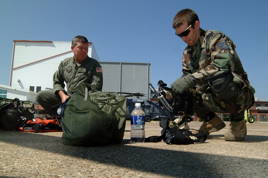 Chief Master Sgt. Jeff Curl, 308th Rescue Squadron and Tech. Sgt. Andrew Canfield, prepare their radios and equipment before taking off on another search and rescue mission over Hurricane Katrina ravaged New Orleans and the Mississippi Gulf coast. (U.S. Air Force photo by Master Sgt. Bill Huntington)