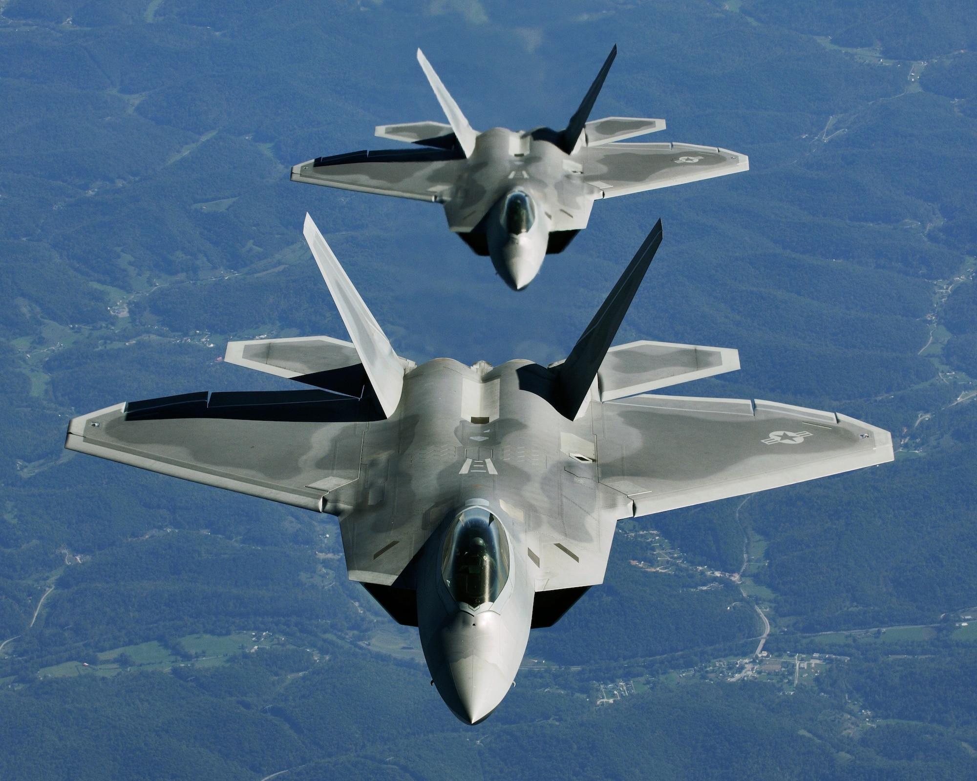 OVER THE MIDWEST -- Lt. Col. James Hecker (front) and Lt. Col. Evan Dertein line up their F/A-22 Raptor aircraft behind a KC-10 Extender to refuel while en route to Hill Air Force Base, Utah. Colonel Hecker commands the first operational Raptor squadron -- the 27th Fighter Squadron at Langley Air Force Base, Va. The unit went to Hill for operation Combat Hammer, the squadron's first deployment, Oct. 15. The deployment has a twofold goal: complete a deployment and to generate a combat-effective sortie rate away from home. (U.S. Air Force photo by TSgt Ben Bloker)