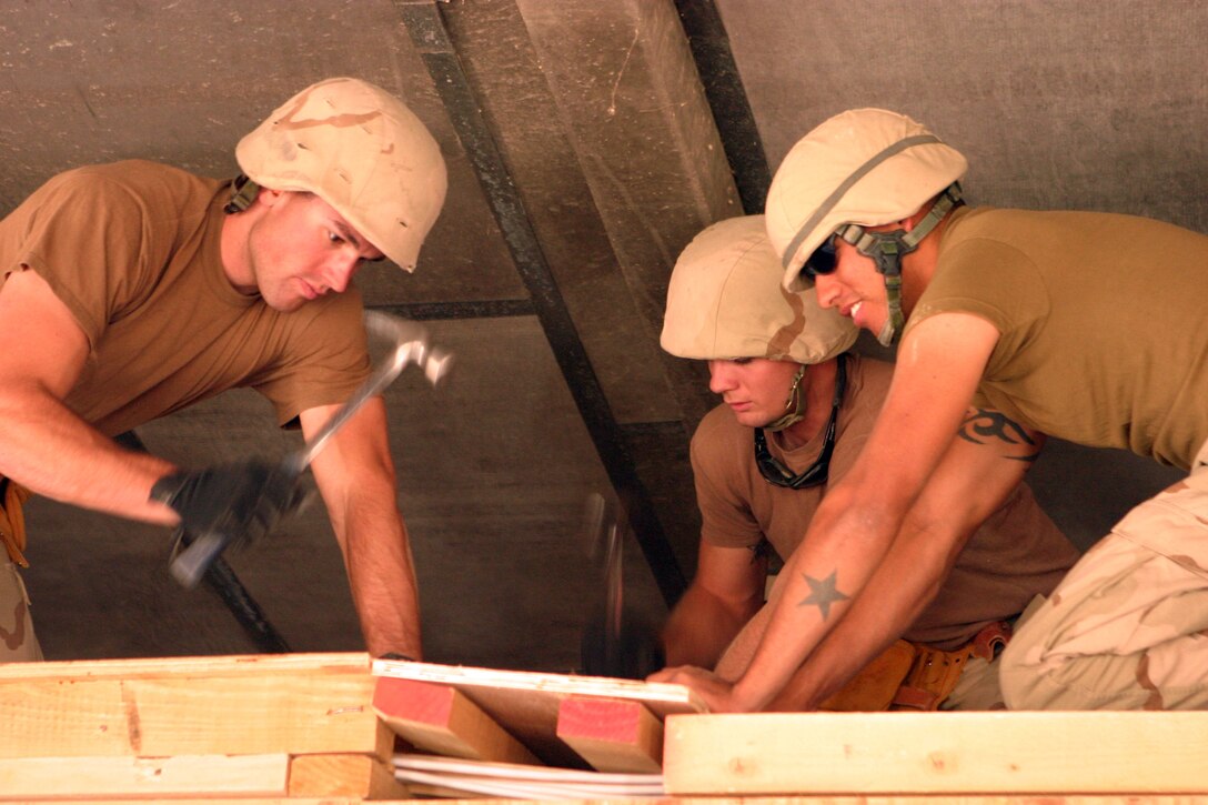 AR RAMADI, Iraq (Oct. 23, 2005) ? Petty Officer 3rd Class Tony J. Marchefka (left), Seaman Robert J. Rogers (center) and Petty Officer 3rd Class Isaac R. Ramirez place a board over the structure at Camp Corregidor here. The Sailors of Naval Mobile Construction Battalion-3 from Detachment Camp Taqaddum, Iraq are currently operating on Camp Corrigedor in downtown Ramadi. Marchefka is an utilitiesman, Rogers is a constructionman, and Ramirez is a builder all with NMCB-3.
