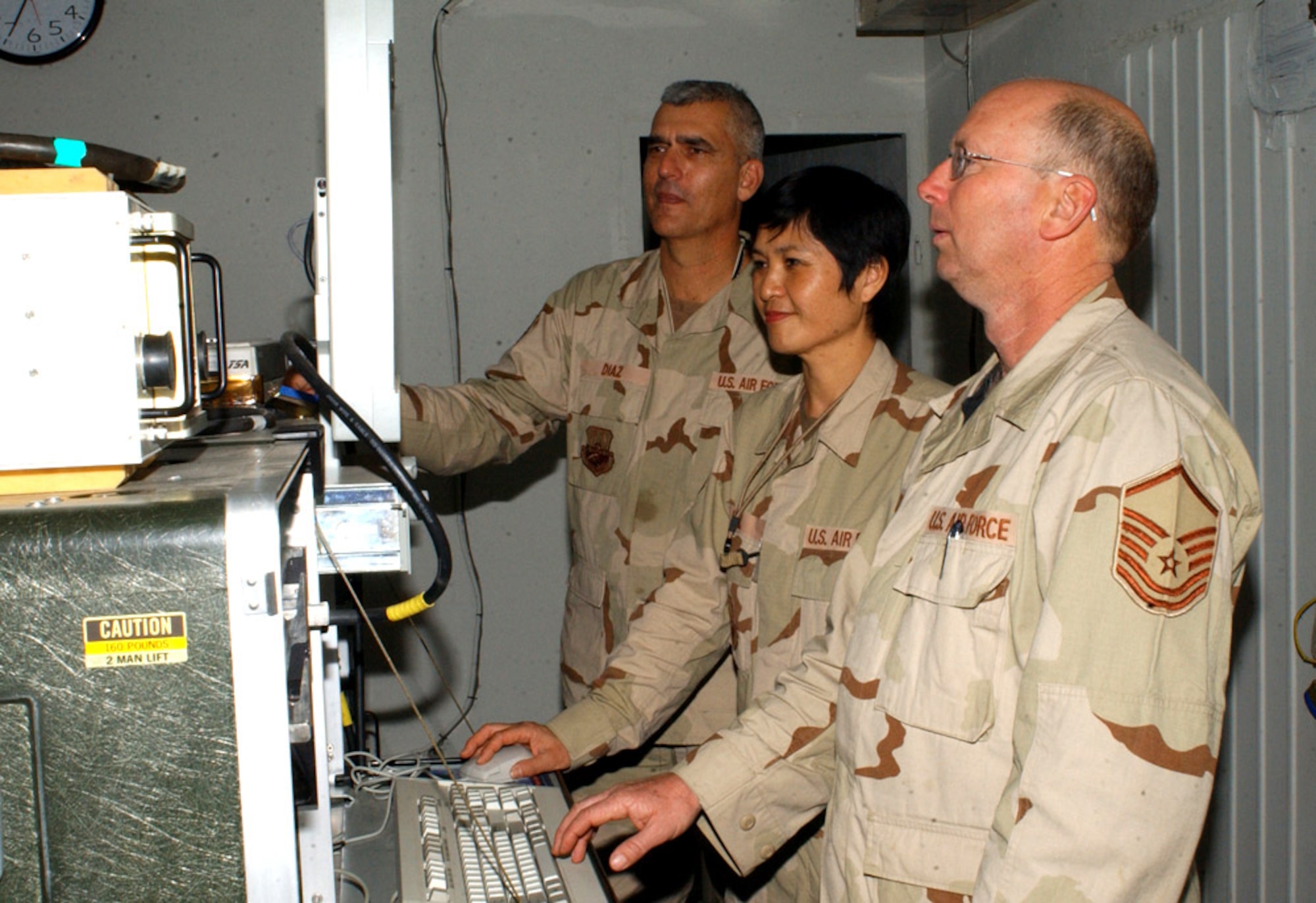 BALAD AIR BASE, Iraq -- (Left to right) Tech. Sgt. Gerardo Diaz, Senior Master Sgt. Huey Hill and Master Sgt. Ralph Cole run a computer confidence check on an improved avionics intermediate system before testing an F-16 Fighting Falcon part. Technicians perform the check each time they test a part. The sergeants are all with the 332nd Expeditionary Maintenance Squadron. (U.S. Air Force photo by Staff Sgt. Tammie Moore)     