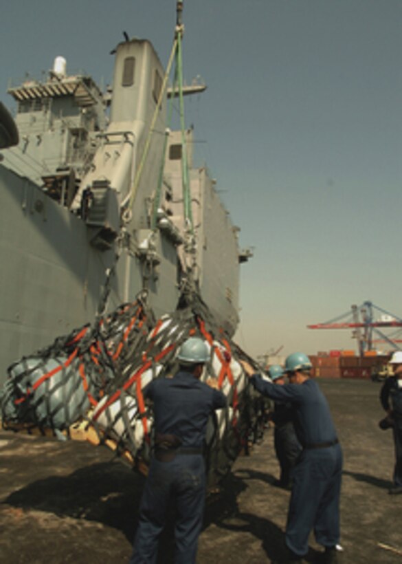 U.S. Navy sailors from the USS Pearl Harbor (LSD 52) guide cargo nets full of relief supplies as they are lowered down from the boat deck of the ship onto the pier in Karachi, Pakistan, on Oct. 24, 2005. The dock landing ship is in Karachi to unload 140 tons of disaster relief supplies for Pakistan. The Department of Defense is delivering disaster relief supplies and services as part of a multinational effort to provide aid and support to Pakistan and parts of India and Afghanistan following a devastating earthquake. 