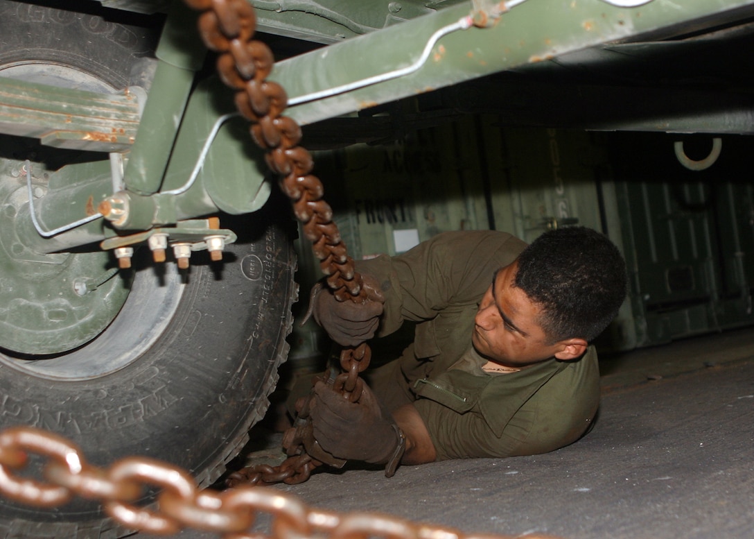 Cpl. Ernesto A. Holguin, a wireman with the 22nd Marine Expeditionary Unit's Command Element, secures a Humvee trailer to the well deck of the USS NASSAU as the MEU begins its final pre-deployment exercise, Sept. 22, 2005.   The Huntington Park, Calif. native is scheduled to deploy with the MEU later this year.