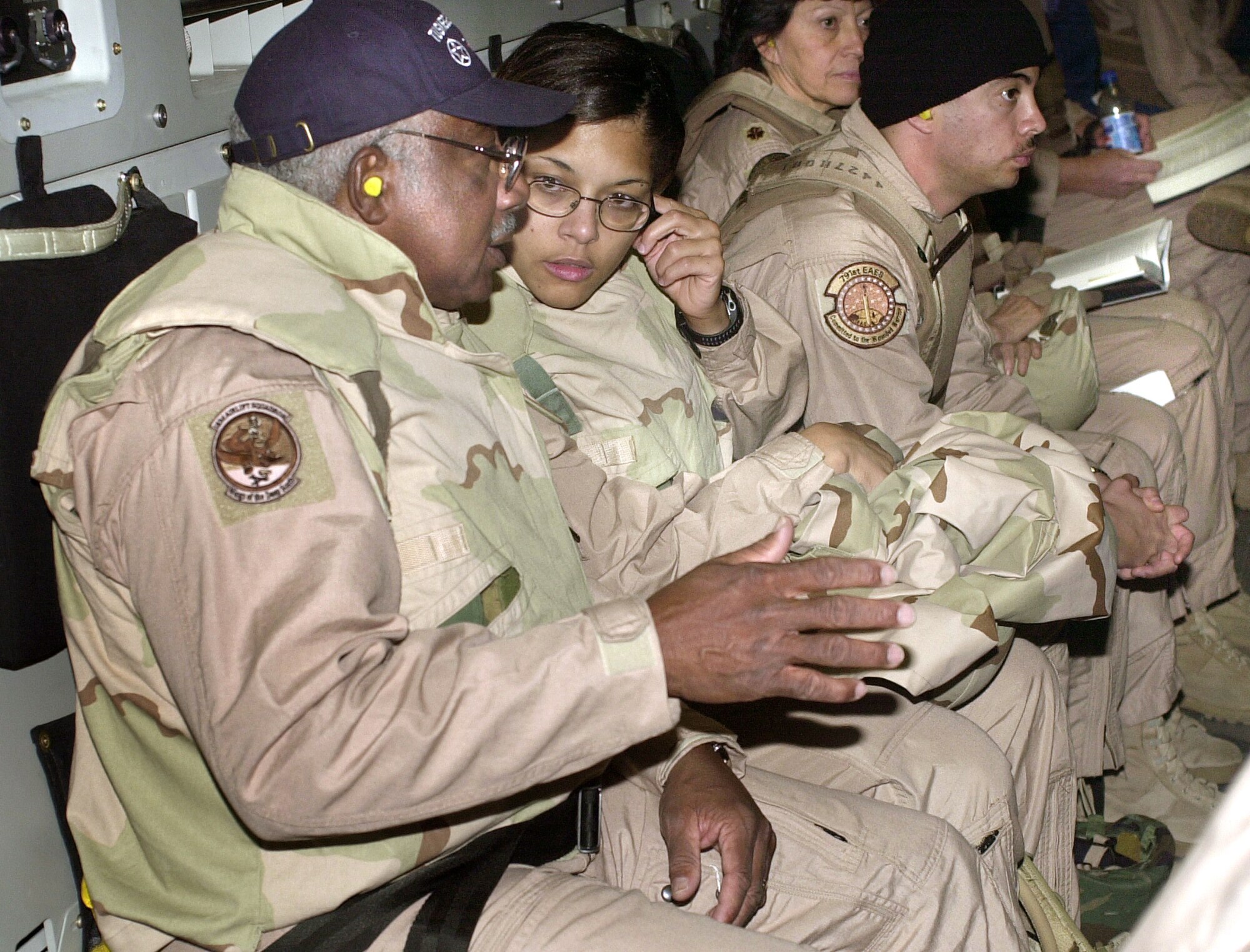 ABOVE IRAQ (AFPN) -- Tuskegee Airman Col. Richard Toliver (left) chats with Maj. (Dr.) Vanessa Williams as their C-17 Globemaster III makes its final approach to Balad Air Base, Iraq. Five of the original Tuskegee Airmen -- the first African-American aviators of World War II -- are visiting the 332nd Air Expeditionary Wing at Balad. The unit is a descendant of the "Red Tail Angels" of the Tuskegee Airmen's 332nd Fighter Group.  (U.S. Air Force photo by Capt. Andra Higgs) 