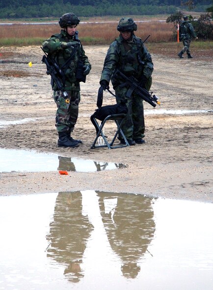 NAVAL AIR ENGINEERING STATION LAKEHURST, N.J. (AFPN) -- Capt. Kevin Walker and Senior Airman Winter Gibson figure out how to set up force protection measures at their camp here. The Airmen, from the 613th Security Forces Squadron at Andersen Air Force Base, Guam, deployed here in support of exercise Eagle Flag 06-1, which began Oct. 21.  (U.S. Air Force photo by Tech. Sgt. Scott T. Sturkol))