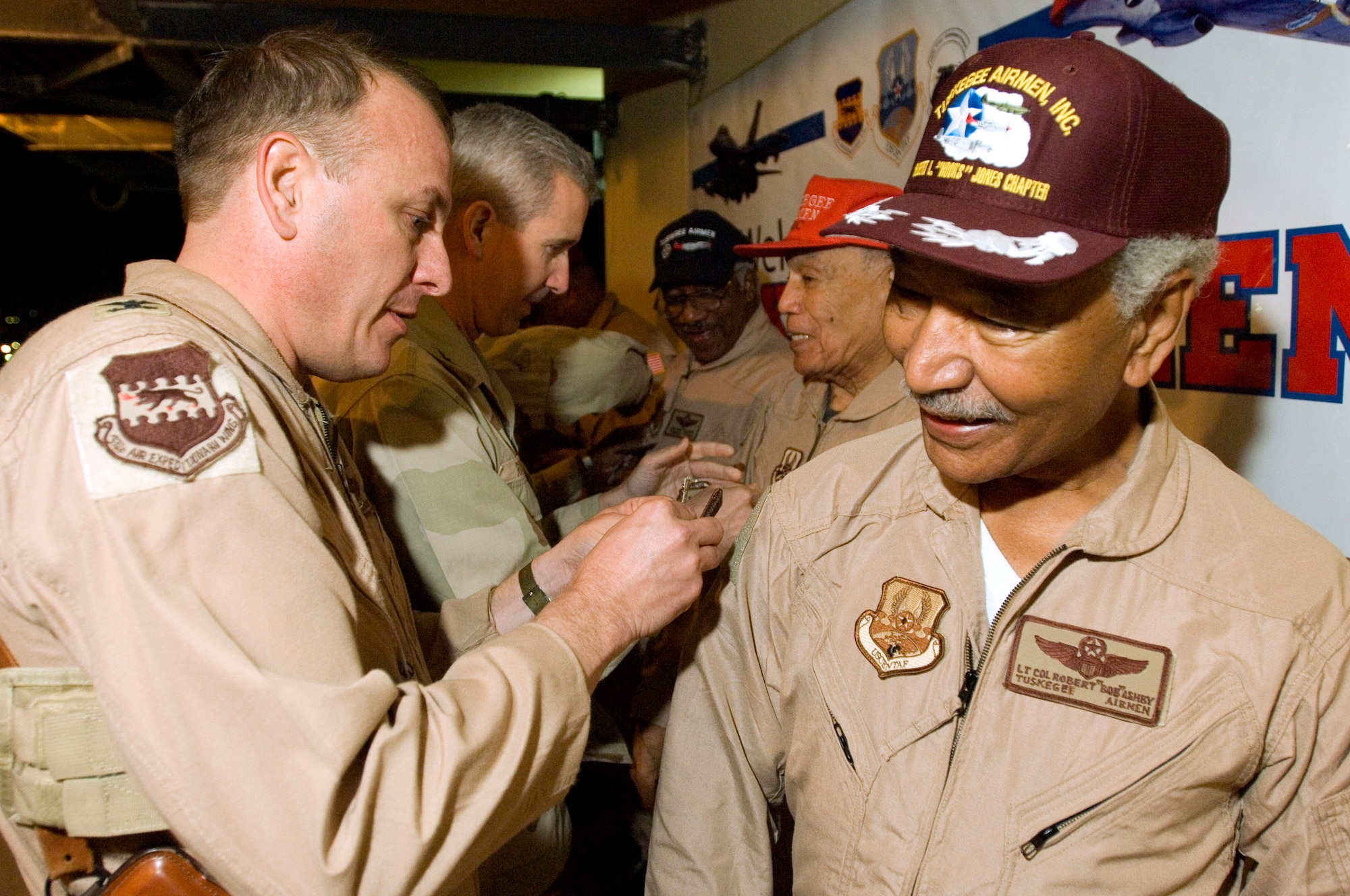 BALAD AIR BASE, Iraq (AFPN) -- Col. Gordon Jacobs (left) puts wing patches onto the uniform of retired Tuskegee Airman Lt. Col Robert Ashby. Colonel Ashby is one of five Tuskegee Airman visiting here. Colonel Jacobs is the 332nd Expeditionary Operations Group commander. The Army created the Tuskegee Airmen unit in 1941. (U.S. Air Force photo by Master Sgt. John E. Lasky)