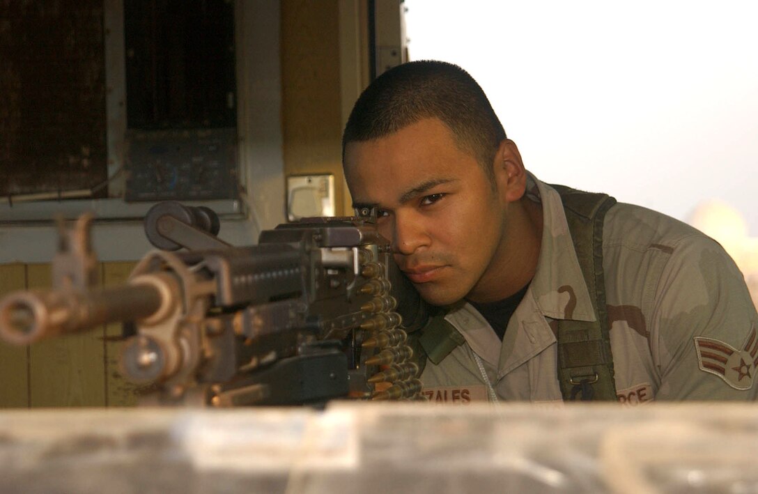 SOUTHWEST ASIA (AFPN) -- Senior Airman Andrew Gonzales looks down the sights of an M-240B machine gun from a guard tower at this desert air base. The Airman is one of many members of the 380th Expeditionary Security Forces Squadron responsible for guarding the installation and safeguarding people and assets. He deployed from the 436th Security Forces Squadron at Dover Air Force Base, Del.  (U.S. Air Force photo by Tech. Sgt. Mike Hammond)