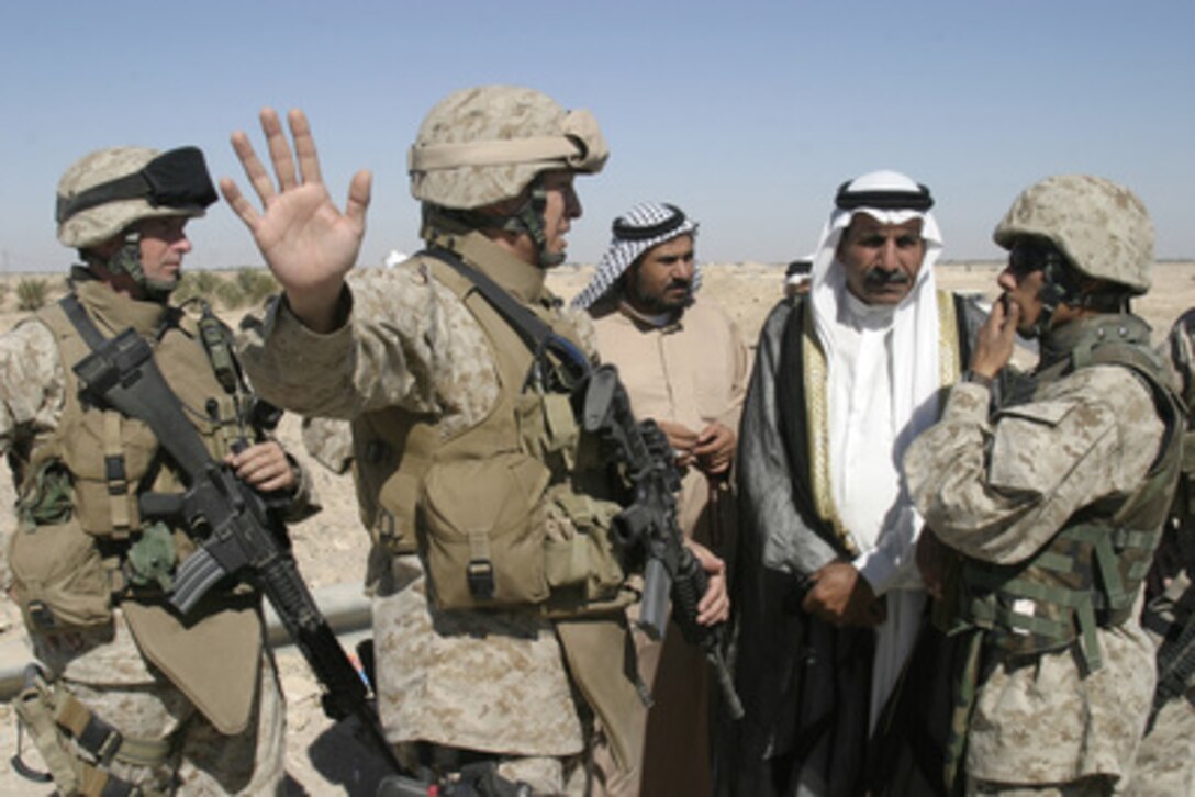 U.S. Marine Lt. Col. Richard O. Miles gestures as he speaks to local sheiks through interpreter about the construction of a burial preparation site for the citizens in Fallujah, Iraq, on Oct. 24, 2005. Miles is the executive officer of Regimental Combat Team 8. 