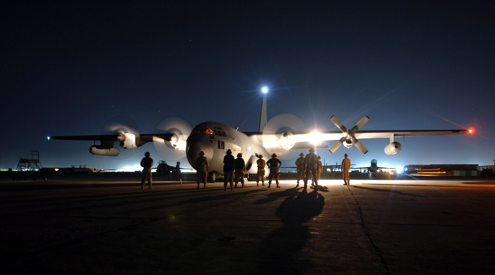 BAGRAM AIR BASE, Afghanistan (AFPN) -- Maintainers' shadows stretch across the tarmac here as they watch an EC-130H Compass Call start its engines before a combat sortie. The aircraft, belonging to the 41st Expeditionary Electronic Combat Squadron, deployed from Davis Monthan Air Force Base, Ariz. It left on its mission Oct. 22. Since November 2004, EC-130s have supported more that 1,500 air-support requests from ground forces participating in Operation Enduring Freedom. (U.S. Air Force photo by Capt. James H. Cunningham)