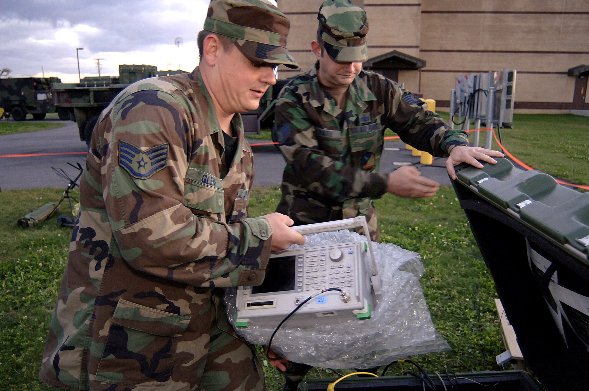 FORT DRUM, N.Y. (AFPN) -- Staff Sgt. Brandon Glenn (left) and Staff Sgt. Kevin Waite unpack communications gear during Exercise Unified Endeavor 06 here. The two sergeants, members of the 712th Air Support Operations Center, ensured communications links were in place to train Army staff on close-air-support operations Oct. 20.  Sergeant Glenn is a satellite communications craftsman, and Sergeant Waite is a computer control systems craftsman. (U.S. Air Force photo by Senior Airman Stephen Otero)
