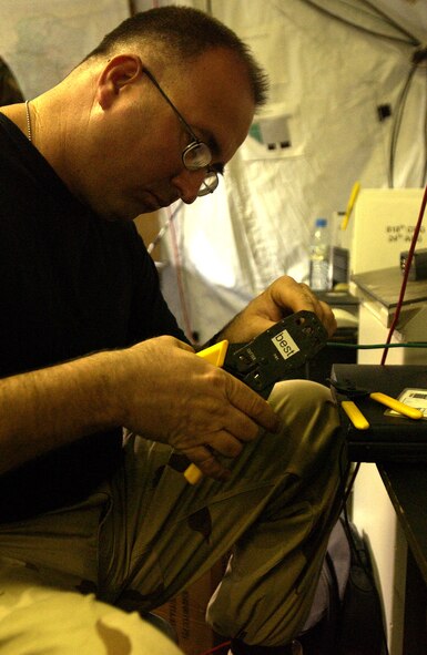 CHAKLALA AIR BASE, Pakistan (AFPN) -- Tech. Sgt. Rick Harbaugh installs a communication cable in support of earthquake-relief efforts here. On Oct. 26, Sergeant Harbaugh, from the 818th Contingency Response Group at McGuire Air Force Base, N.J., helped the Air Force deliver assistance to Pakistan following the Oct. 8 earthquake. (U.S. Air Force photo by Tech. Sgt. Jeromy K. Cross)