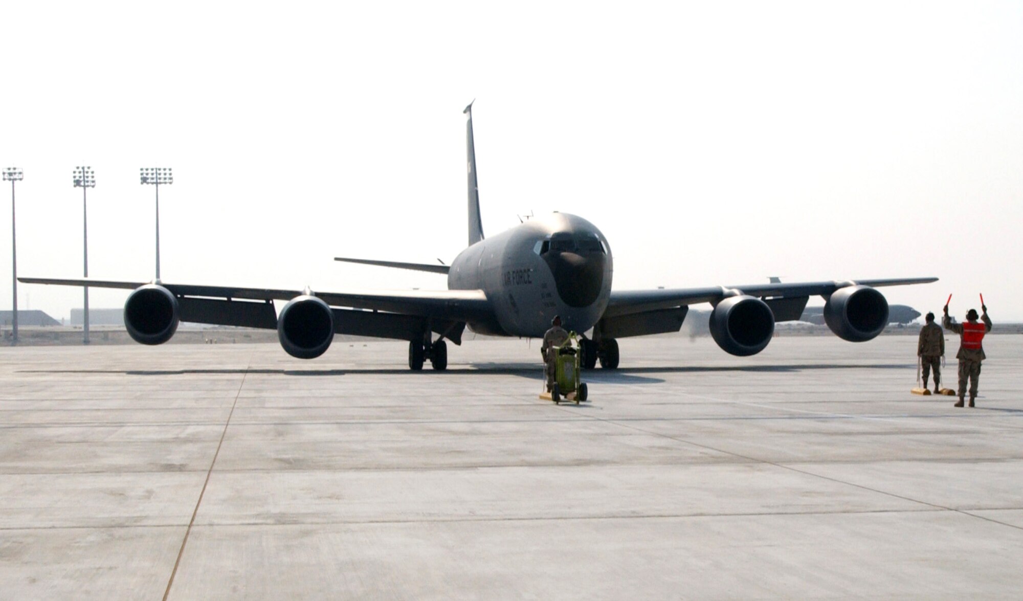 SOUTHWEST ASIA (AFPN) -- A crew chief signals to the pilot of a KC-135 as the aircraft becomes the first to taxi onto this desert air bases new tanker ramp Oct. 22. The new ramp allows the 380th Air Expeditionary Wing to consolidate many of its aircraft in one area, increasing efficiency. (U.S. Air Force photo by Senior Airman Dierra Stokes) 