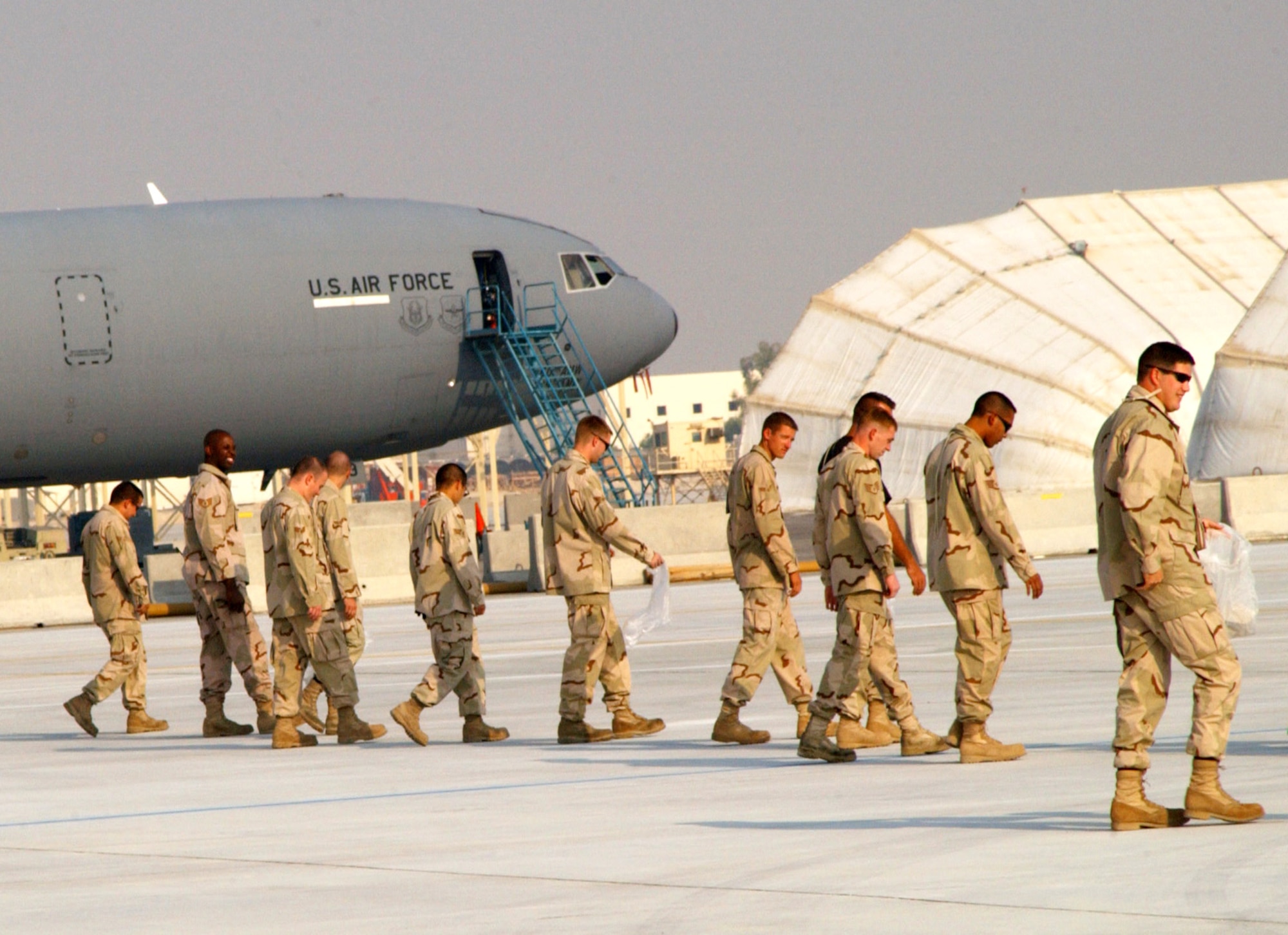SOUTHWEST ASIA (AFPN) -- Some of the more than 200 members with the 380th Air Expeditionary Wing perform a Foreign Object Damage walk Oct. 22., prior to the opening ceremony of this desert air base's new tanker ramp. The Airmen removed any loose debris from the flightline in an effort to reduce the potential for damage to aircraft. (U.S. Air Force photo by Senior Airman Dierra Stokes)