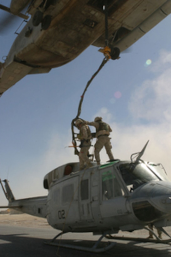 U.S. Marines from Combat Logistics Battalion 2 stand atop a UH-1N Huey as they hook it up to a CH-53 Super Stallion for an external lift from Al Qaim, Iraq, on Oct. 25, 2005. Marine Heavy Helicopter Squadron 466 is deployed to Iraq in support of Operation Iraqi Freedom. 