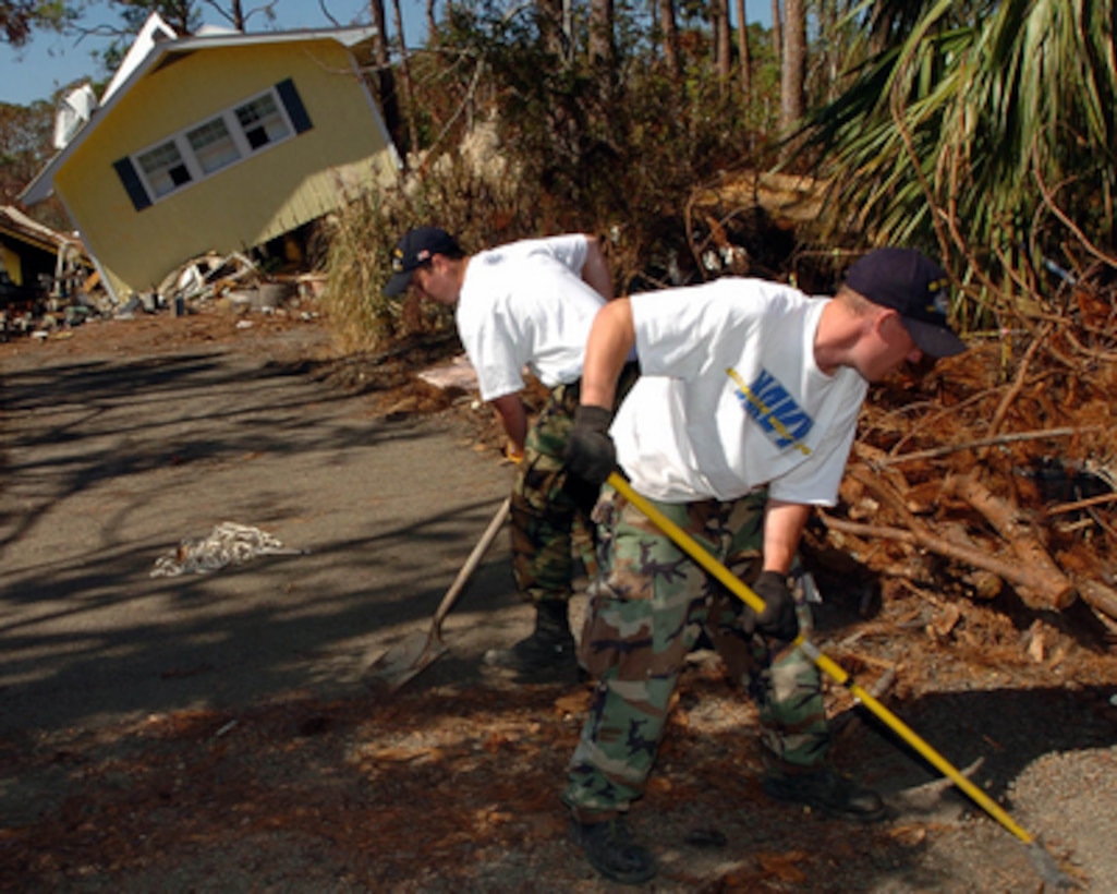 U.S. Navy Airman Salvatore Lombardi and Fireman Andrew Westermire help citizens in Pass Christian, Miss., clear away debris left from Hurricane Katrina on Oct. 26, 2005. Both sailors are assigned to the aircraft carrier USS John C. Stennis (CVN 74). 