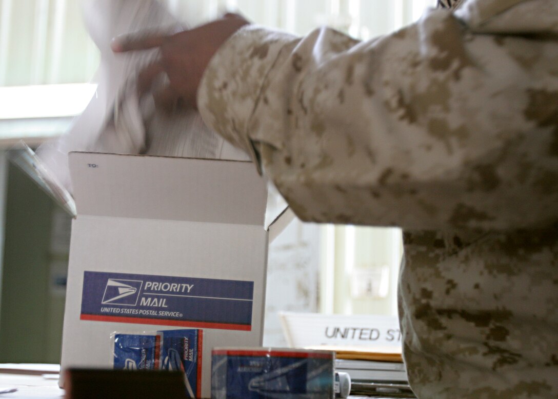 Corporal Marcus D. Kibble, inspecting noncommissioned officer, Postal Detachment 6, Service Company, Headquarters and Service Battalion, 2nd Force Service Support Group (FWD), serves as a link between Marines here, and their families at home. Kibble assists in the Camp Fallujah Post Office, monitoring packages that come through the office.