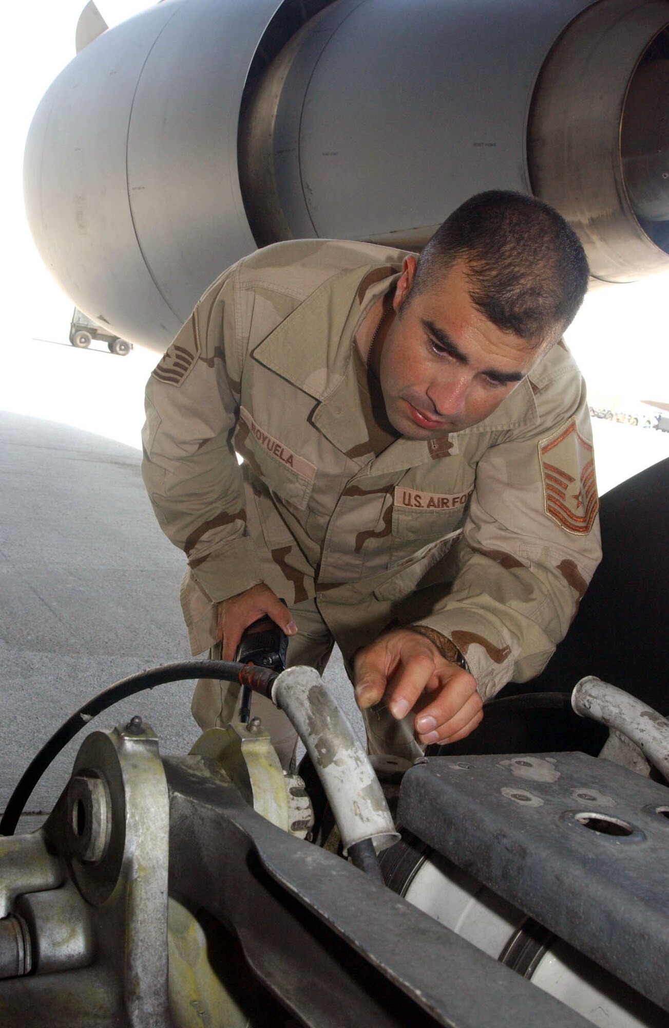 SOUTHWEST ASIA (AFPN) -- Master Sgt. James Royuela inspects brake lines on the main landing gear of a KC-10A Extender aircraft on the flightline of this desert air base Oct. 26. Sergeant Royuela supervises an aircraft maintenance unit of 21 members devoted to inspecting and maintaining several of the $85 million refueling aircraft used for aerial refueling of coalition aircraft supporting ground forces. He is deployed to a non-disclosable location from the 660th Aircraft Maintenance Squadron based at Travis AFB, Calif. (U.S. Air Force photo by Tech. Sgt. Mike Hammond)